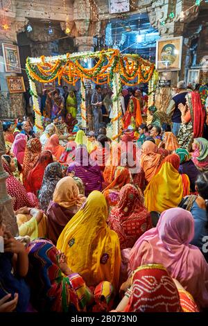 Donne indiane con vestiti colorati durante la cerimonia all'interno del Tempio di Jagdish, Udaipur, Rajasthan, India Foto Stock