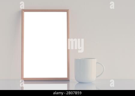 Tazza da caffè bianca e cornice vuota sul tavolo Foto Stock