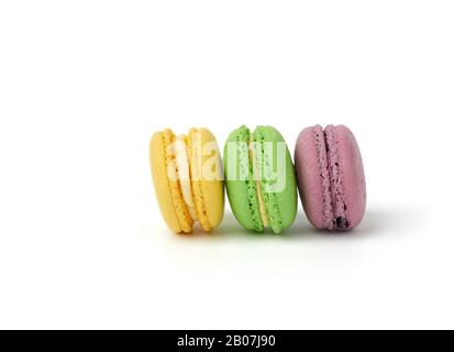 tre torte di macaron tondi multicolori, isolate su uno sfondo bianco, stand dessert di fila Foto Stock