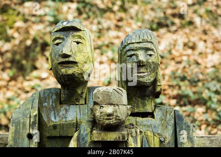 La famiglia Woodland, una scultura rustica in legno di una famiglia sul Tarka Trail fuori Great Torrington, Devon, Inghilterra Foto Stock