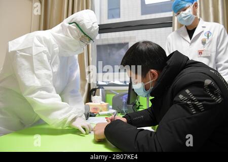 Nanchang, Cina. 19th Feb 2020. Dong, un paziente di coronavirus recuperato, segni per la donazione di plasma in un ospedale a Nanchang, nella provincia di Jiangxi nella Cina orientale, 19 febbraio 2020. Dong, 42 anni, è il primo paziente recuperato che ha donato il suo plasma dopo il recupero dal coronavirus nella provincia di Jiangxi. (Xinhua/Peng Zhaozhi) Credito: Xinhua/Alamy Live News Foto Stock