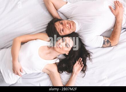 Ritratto di stile di vita di giovane coppia sdraiata a letto Foto Stock