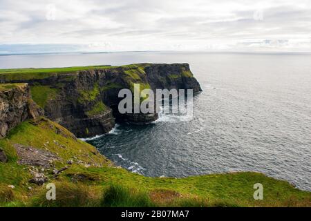 Le scogliere di Moher a Co Clare nell'Irlanda occidentale hanno preso in un giorno coperto. Queste scogliere sono una vista impressionante e la cima della scogliera a piedi con Atla Foto Stock