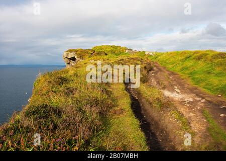 La pista sterrata alle scogliere di Moher a Co Clare, nell'Irlanda occidentale, ha preso parte a una giornata travoliata. Queste scogliere sono una vista impressionante e la scogliera Foto Stock