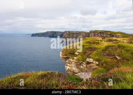 Le scogliere di Moher a Co Clare nell'Irlanda occidentale hanno preso in un giorno coperto. Queste scogliere sono una vista impressionante e la cima della scogliera a piedi con Atla Foto Stock