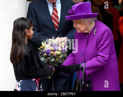 La regina Elisabetta II riceve un bouquet da una giovane ragazza mentre lascia dopo aver aperto ufficialmente i nuovi locali del Royal National ENT e degli ospedali dentali Eastman a Londra. Foto Stock