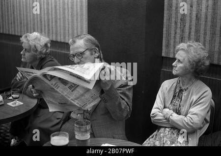 Annoiato coppia, l'uomo che legge un giornale ignorando sua moglie. Working Mens Club Sabato sera dopo il Bingo intrattenimento serale. 1980s Coventry Inghilterra. HOMER SYKES Foto Stock