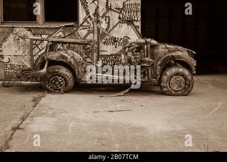 Una vecchia auto completamente distrutta, Old Car Wreck, a contrasto piatto, foto in bianco e nero, seppia Foto Stock