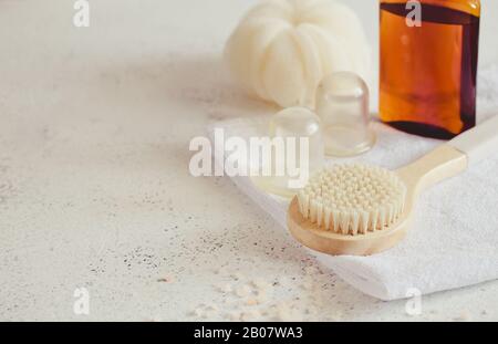 Spa concetto di bellezza. Massaggio anticellulite. Accessori bagno su sfondo bianco pietra, vista dall'alto, copia spazio / Foto Stock