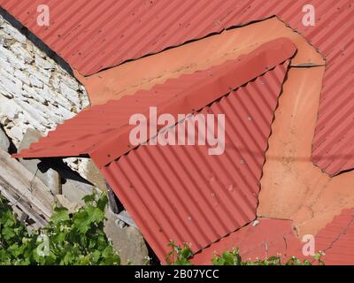 Rosso, tetto di ferro corrugato su costruzione di pietra a Metsovo, Epiro, Grecia Foto Stock