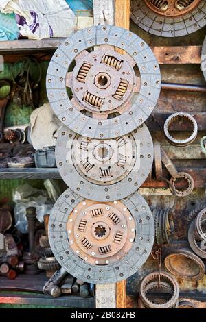 Primo piano di una serie di vecchi dischi arrugginiti usati appesi in linea in un negozio di auto spazzatura accanto ad altre parti di auto, visto in Iloilo City, Filippine, Asia Foto Stock