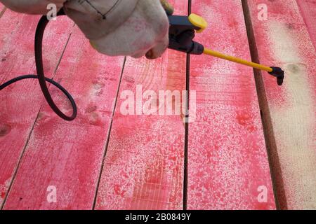 Il lavoratore dipinge i pannelli con l'aiuto di un nebulizzatore.2020 Foto Stock