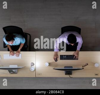 Ambiente di tarda notte, vista dall'alto del team degli operatori del call center con cuffie che lavorano in un call center, servizio clienti e supporto tecnico. Utilizzo di per Foto Stock
