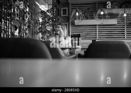 Šamac, Bosnia e Erzegovina, Ott 3, 2019: Donna seduta in una caffetteria Foto Stock