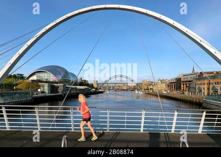 Jogger Femmina, Il Gateshead Millennium Bridge / Il Lampeggiante Eye Bridge E Sage Gateshead, Newcastle Upon Tyne, Tyne E Wear, Inghilterra, Regno Unito, Europa Foto Stock