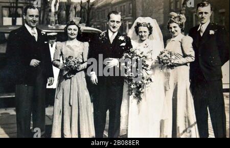 Una fotografia formale di un gruppo di nozze nel 1940 a Blackpool, Lancashire, Regno Unito. Ida Gregory sposa Sid Waller. Sulla destra, Alfred Gregory, fratello di Ida Gregory, in seguito membro della spedizione britannica del Monte Everest del 1953 che ha fatto la prima salita del Monte Everest; era responsabile della fotografia delle immagini fisse. Come membro della squadra di arrampicata, ha raggiunto i 28,000 piedi (8,500 metri) a sostegno del successo dell'assalto Hillary-Tenzing sulla cima. Più tardi, per 20 anni, ha lavorato come freelance per Kodak UK, insegnando sulla fotografia. Foto Stock