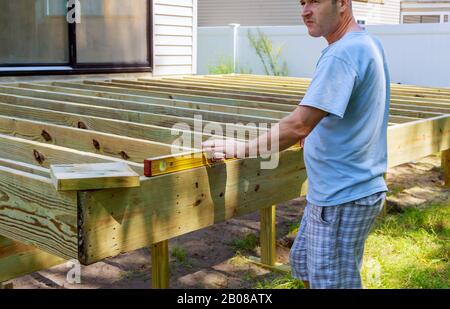 Installazione di pavimento in legno per il patio con il ponte di legno nuovo frammento decking tavole Foto Stock