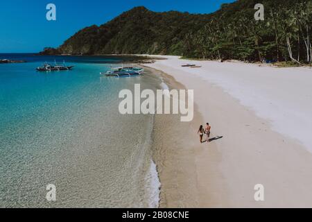 Coppia godendo del tempo di fronte alla spiaggia di Coron. Concetto circa l'estate, lifestyle, viaggio di wanderlust e la natura Foto Stock