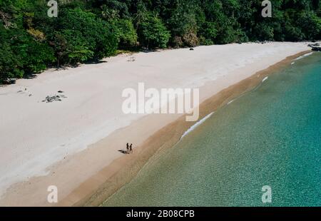 Coppia godendo del tempo di fronte alla spiaggia di Coron. Concetto circa l'estate, lifestyle, viaggio di wanderlust e la natura Foto Stock