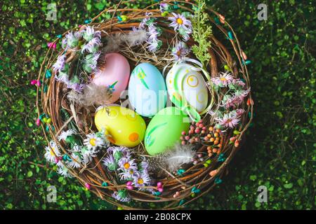 Felice Pasqua. Congratulazioni sfondo pasqua. Uova di Pasqua e fiori. Sfondo con copia spazio. Messa a fuoco selettiva. Vista dall'alto. Foto Stock