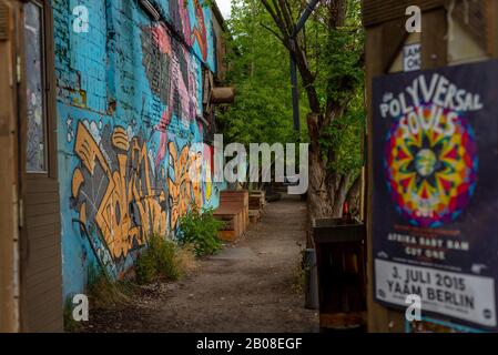 Berlino, Friedrichshain. Riferimenti a YAAM, Young African Art Market con muro coperto di variopinte Street art Foto Stock