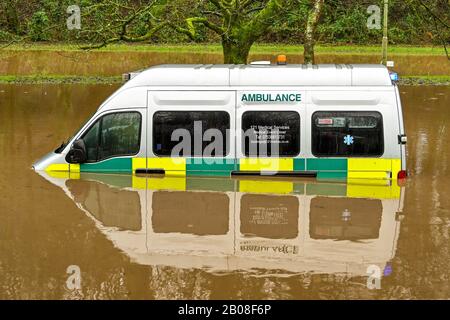 Nantgarw, NEI PRESSI DI CARDIFF, GALLES - FEBBRAIO 2020: L'ambulanza sommersa in acque meteoriche dopo che il fiume Taff ha fatto scoppiare le sue banche vicino Cardiff. Foto Stock