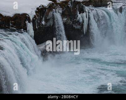 Un primo piano della cascata di Godafoss in Islanda con neve e ghiaccio Foto Stock