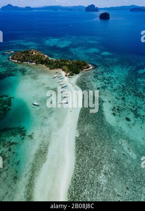 Godetevi il tempo in spiaggia. Persone che camminano sulla sabbia bianca, con giungla tropicale sullo sfondo. Concetto di viaggio e natura Foto Stock