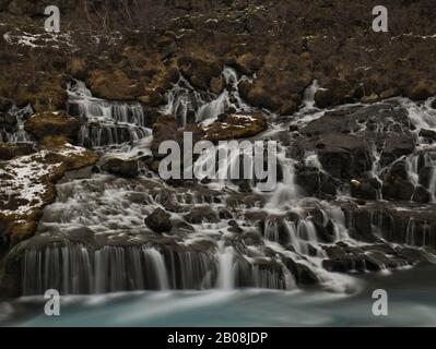 Un'esposizione lunga in inverno dalle cascate di Hraunfossar in Islanda Foto Stock