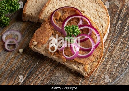 Pane con lardo di maiale mescolato con crepitings macinati, decorato con anelli di cipolla Foto Stock