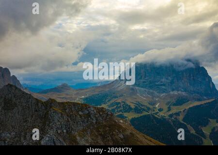 Vista aerea del Brunecker Turm, Sassolungo montagna e passo passo Gardena durante il tramonto. Dolomiti in Alto Adige Foto Stock