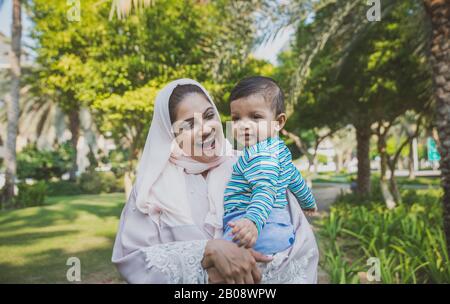 Momenti di stile di vita felici. Mamma e il suo bambino si divertano a Dubai all'aperto in un parco. Foto Stock