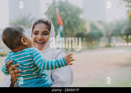 Momenti di stile di vita di madre e figlio a Dubai. Giovane donna con il suo bambino all'aperto. Concetti di famiglia negli Emirati Arabi Uniti Foto Stock