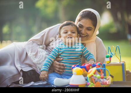 Momenti di stile di vita felici. Mamma e il suo bambino si divertano a Dubai all'aperto in un parco. Foto Stock