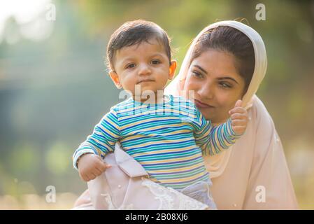 Momenti di stile di vita felici. Mamma e il suo bambino si divertano a Dubai all'aperto in un parco. Foto Stock