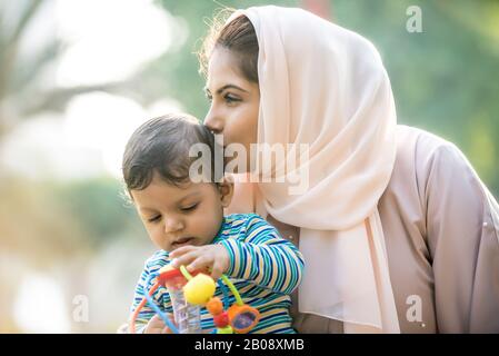 Momenti di stile di vita di madre e figlio a Dubai. Giovane donna con il suo bambino all'aperto. Concetti di famiglia negli Emirati Arabi Uniti Foto Stock