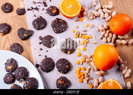 Biscotti al cioccolato fatti a mano con arancia, cannella e noci. Caramelle, cioccolato, agrumi, cannella. Vista dall'alto Foto Stock