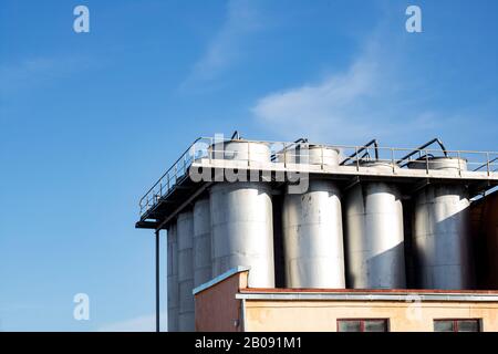 Grandi contenitori industriali in metallo su sfondo blu cielo Foto Stock
