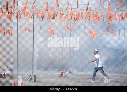 Un lavoratore di pirotecnica durante una celebrazione della mascleta presso il Municipio di Valencia durante il Festival di Fallas in Spagna. Foto Stock