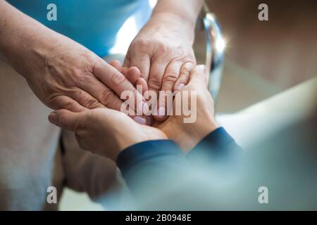 Mani di una donna matura o caregiver di cura e di sostegno. Primo piano. Foto Stock