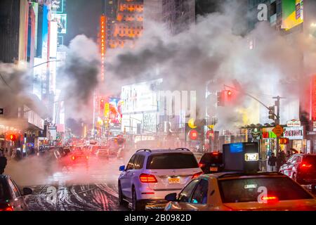 Il vapore che deriva circonda la gente, il traffico e gli edifici Di Times Square nella notte innevata a Midtown Manhattan New York City NY USA il 18 gennaio 2020 Foto Stock