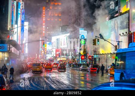 Il vapore che deriva circonda la gente, il traffico e gli edifici Di Times Square nella notte innevata a Midtown Manhattan New York City NY USA il 18 gennaio 2020 Foto Stock