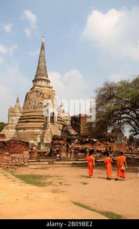 Giovane monaco novizio camminando di fronte a un'antica rovina buddhista, Thailandia Foto Stock