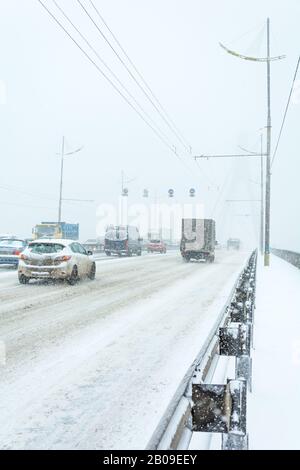 Kiev, Ucraina - 29 novembre 2016: il movimento di trasporto presso il ponte di Mosca durante una tempesta di neve. A Kiev, Ucraina Foto Stock