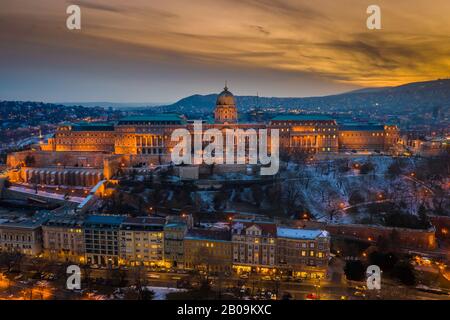 Budapest, Ungheria - veduta aerea del Castello reale di Buda, innevato, con un bel tramonto d'oro nel pomeriggio d'inverno Foto Stock