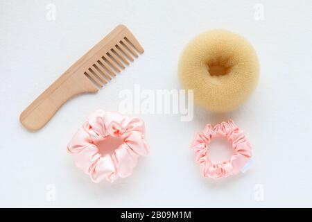 Spazzolina in legno, barrette e scorconcino rosa isolato su bianco. Strumenti E accessori Per Acconciature a disposizione piatta per capelli colorati Scrunchies, capelli Elastici Foto Stock