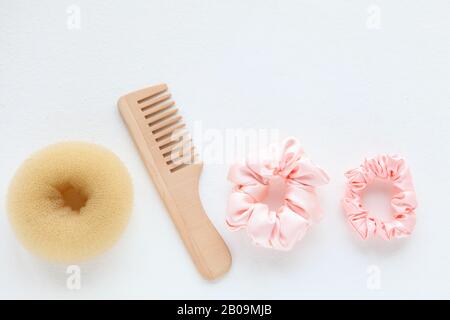 Spazzolina in legno, barrette e scorconcino rosa isolato su bianco. Strumenti E accessori Per Acconciature a disposizione piatta per capelli colorati Scrunchies, capelli Elastici Foto Stock