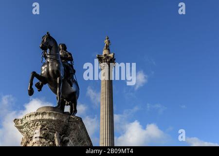 Statua equestre di Carlo i, e la Colonna di Nelson sullo sfondo contro il cielo blu, Trafalgar Square, Londra, Regno Unito Foto Stock