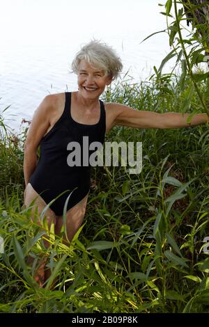 bellissima donna di 65 anni che nuotava nel lago Foto Stock