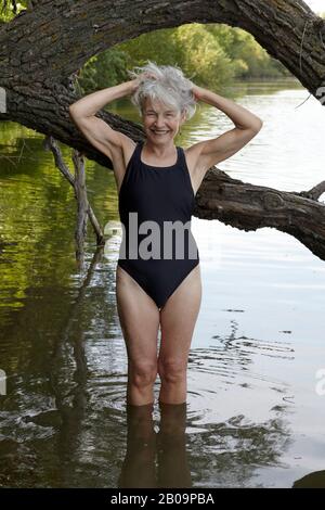 bellissima donna di 65 anni che nuotava nel lago Foto Stock